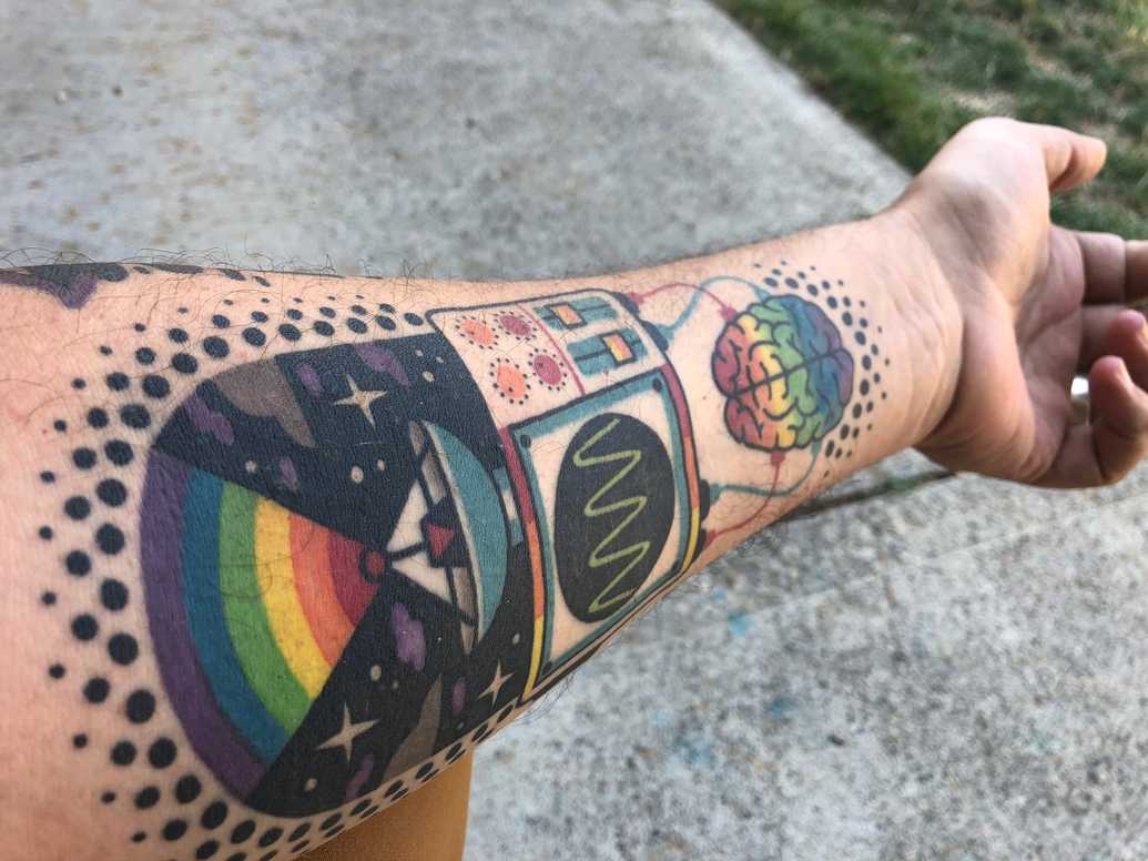 a tattoo of rainbows shooting out of an ocilloscope into space