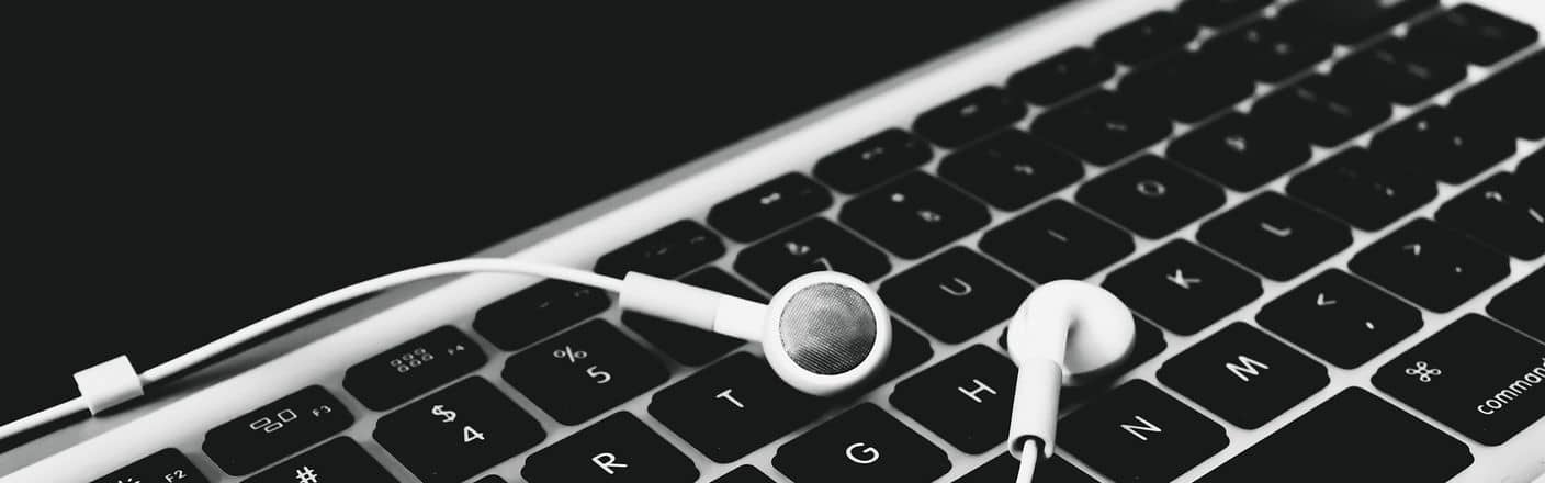 Laptop mit Kopfhörern Laptoptastatur mit weißen Kopfhörern
