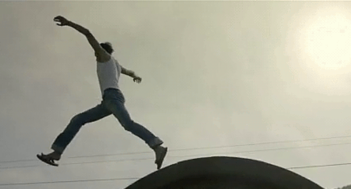 An animated gif of a scene from the movie 'The Continent' of a young man jumping across the tops of concrete culverts.