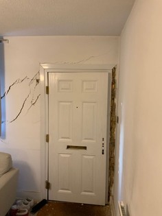 unsecured door and a wall damage