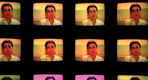 A screenshot showing rows of TV sets showing the face of a woman in the film, 'The Terrorizers'.