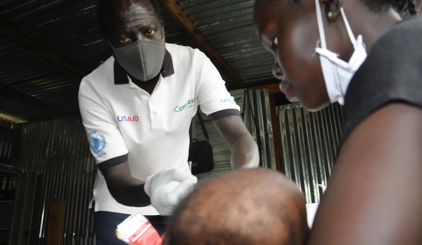 Concern Nurse Yin Jock Deng, screens a child for malnutrition at a POC camp in Juba.