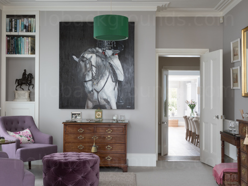 Sophisticated drawing room with a purple furniture theme and a black and white painting of a person on a horse  Zoom background