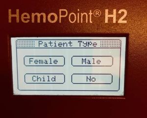 A photo of a HemoPoint H2 device LCD screen with "Patient Type" and selectable options for "Female", "Male", "Child", "No"