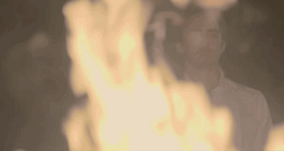 Lee Pace, as protagonist Joe MacMillan in AMC's Halt and Catch Fire, stares solemnly at a raging fire.