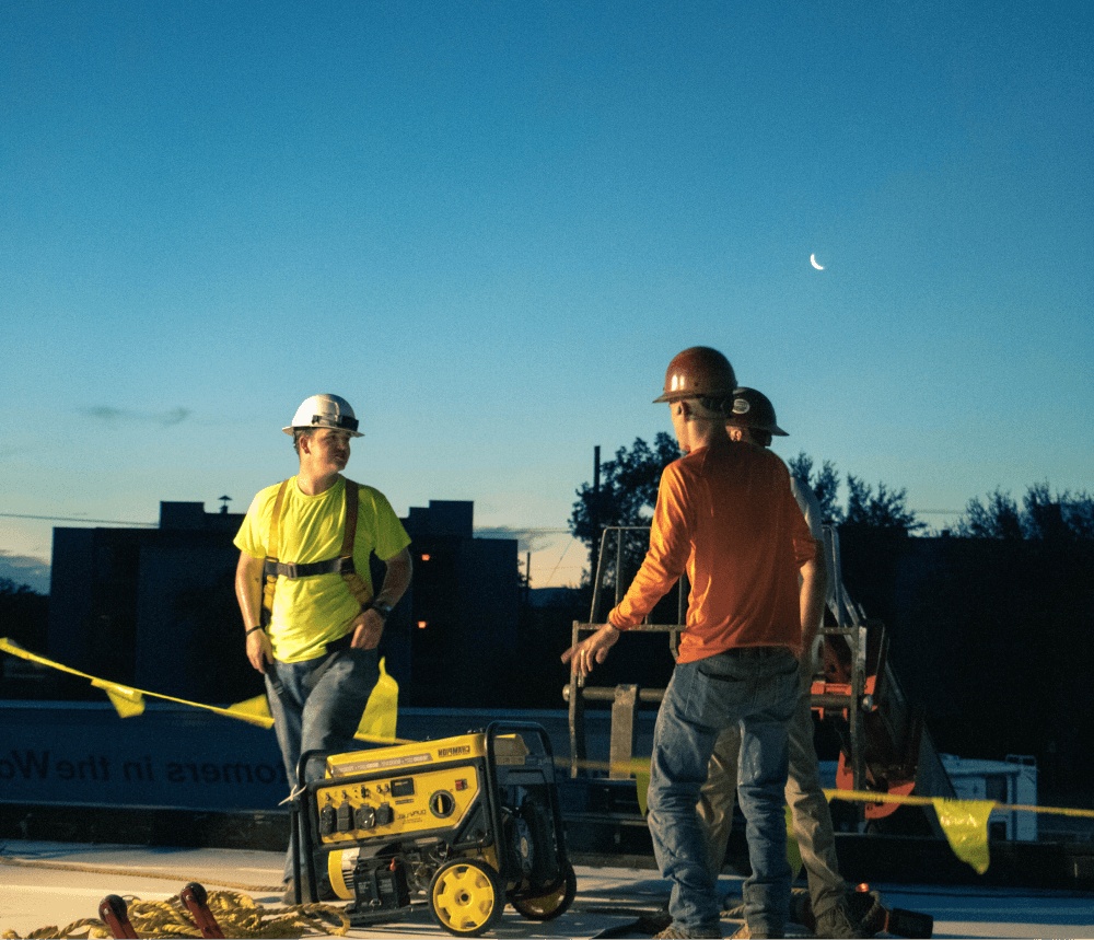 Workers chatting on a rooftop at dusk