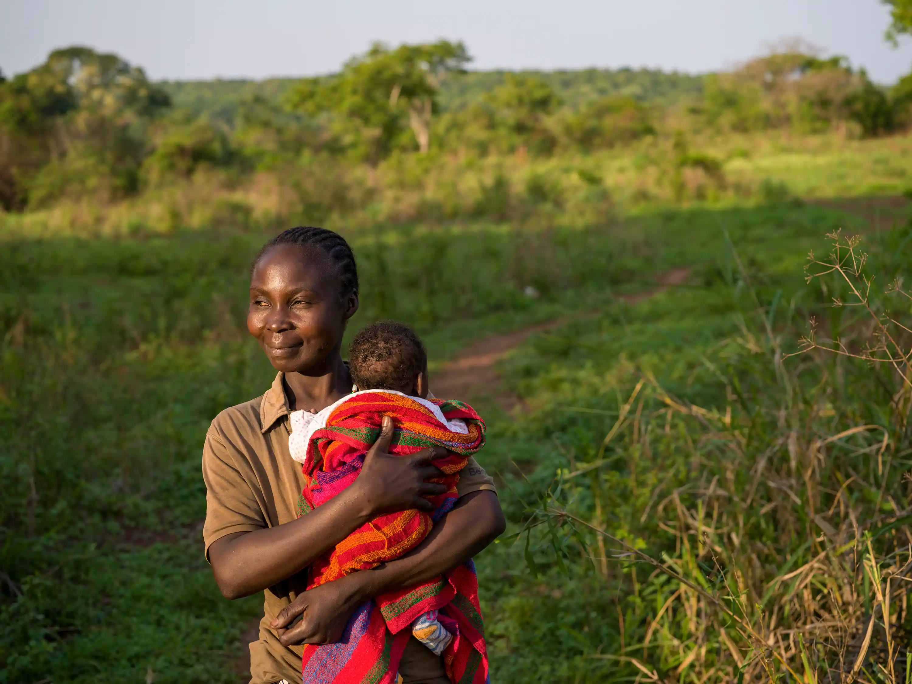 Natalie Wato (33) with her five-week-old son Sauvenator on the small plot of land the family tends near their home in Central African Republic.