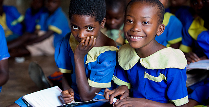 Children smiling while wearing school uniforms