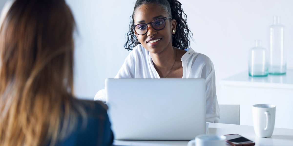 What's the difference between regression and classification in data analytics? A data analyst sitting with a laptop, smiling