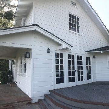 white painted home exterior with dark painted deck
