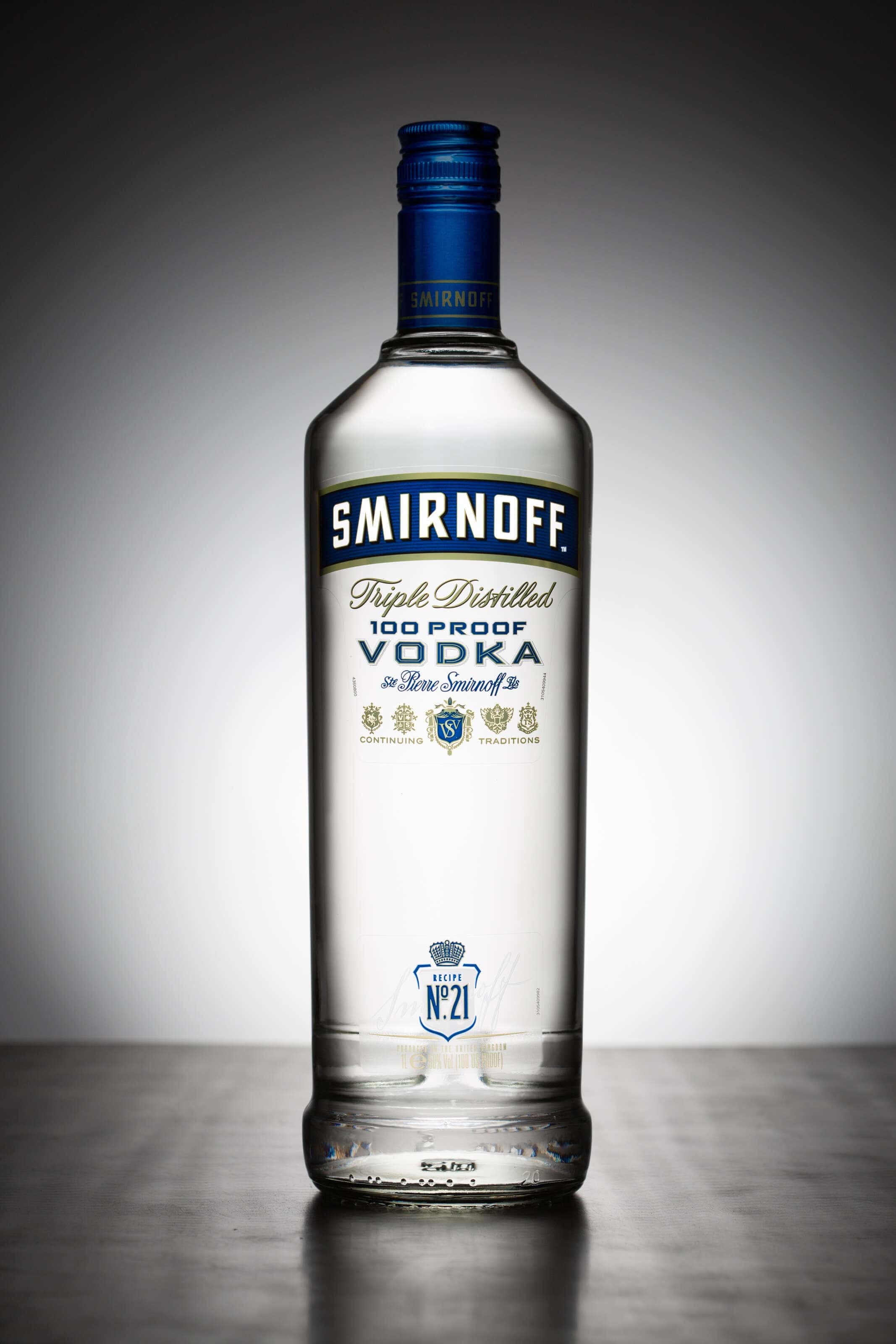 Smirnoff bottle image shot sitting on brushed stainless steel with a white halo behind.