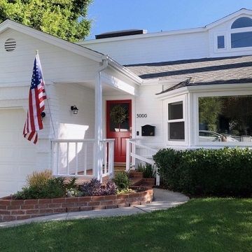 White home with a red door and american flag
