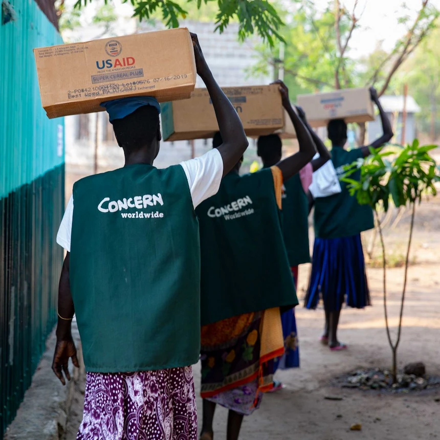Women carrying boxes of supplementary therapeutic food for children