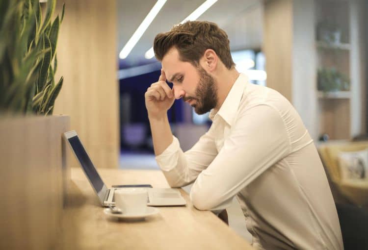 Mann überlegt vor Laptop Mann vor Laptop