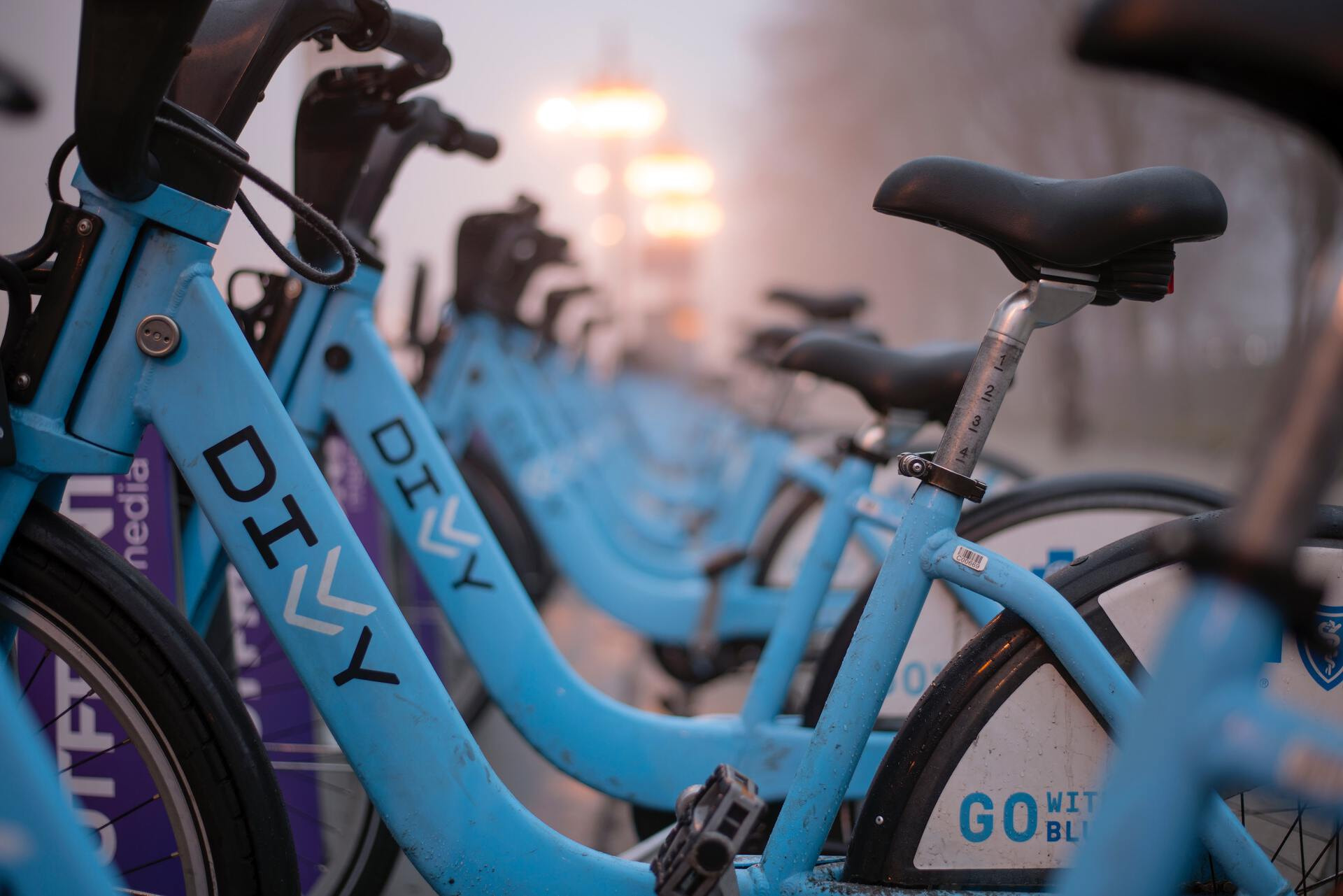 Blue colored station-based sharing bikes standing next to each other.