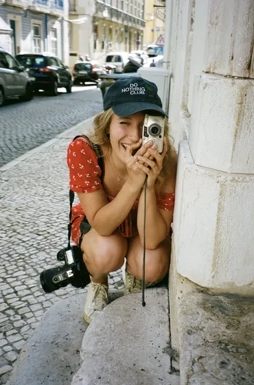 Photograph of Kirsty crouching down, taking a picture with an old style digital camera