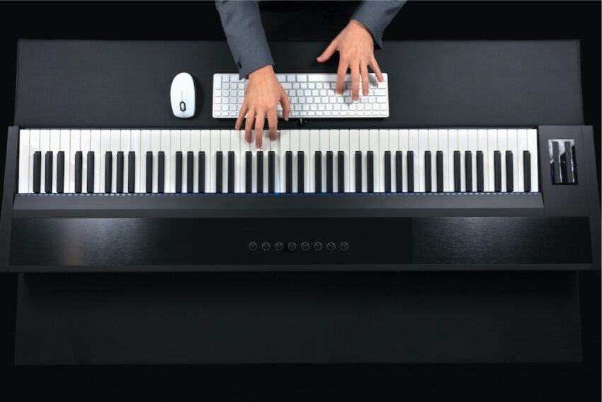 persona con teclado electrónico de 88 teclas contrapesadas y ratón con teclado