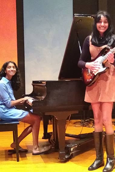 two girls playing guitar and piano