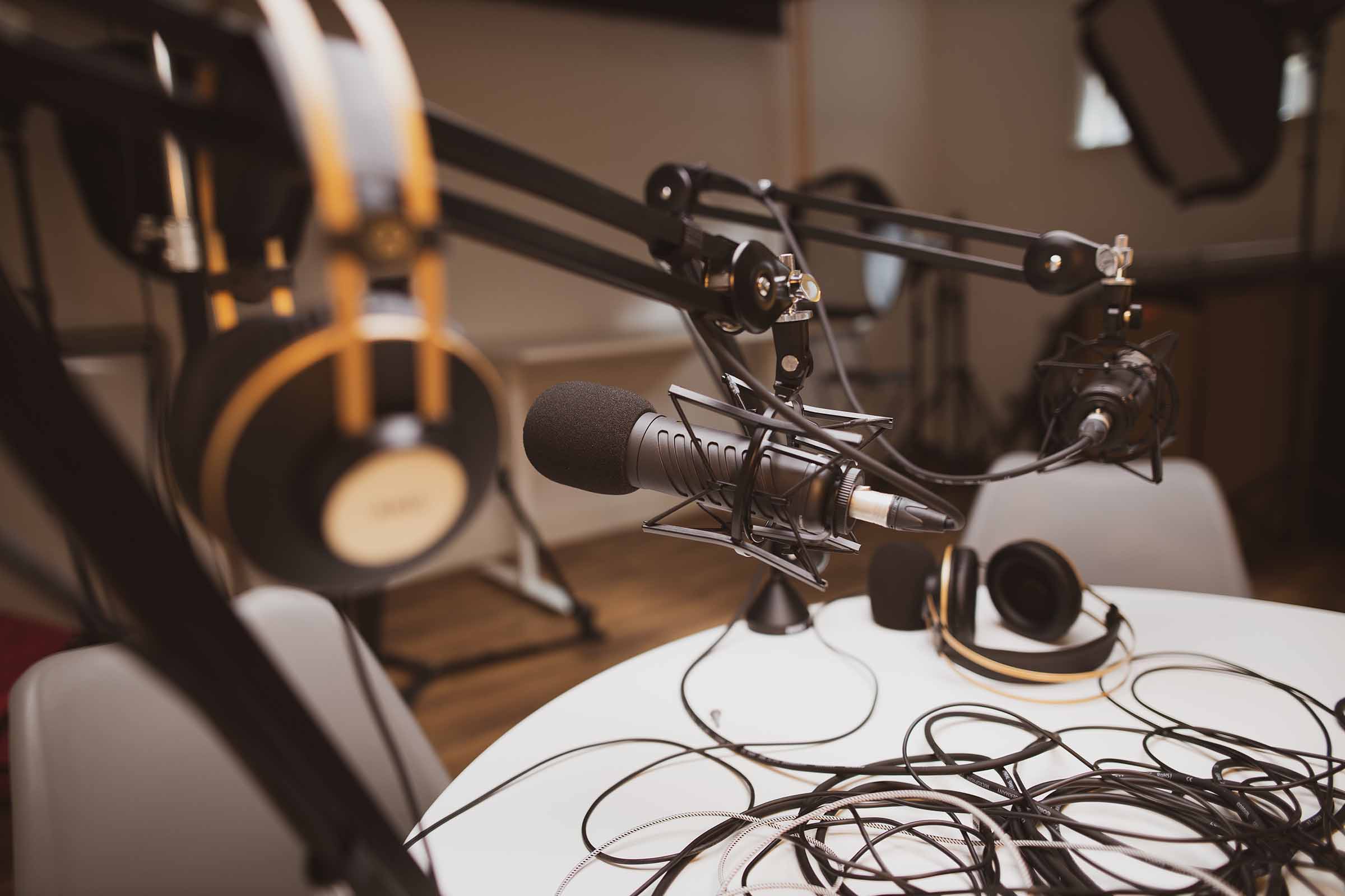 A podcast production style setup with microphone and headphones on a table