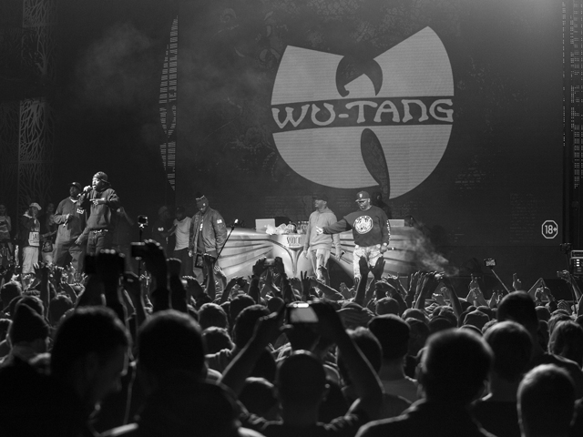 Nine members of the Wu-Tang Clan on stage at a concert
