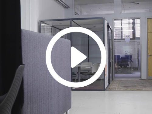 Minimalistic meeting space with private glass cube meeting room containing simple white chairs and table Microsoft Teams background