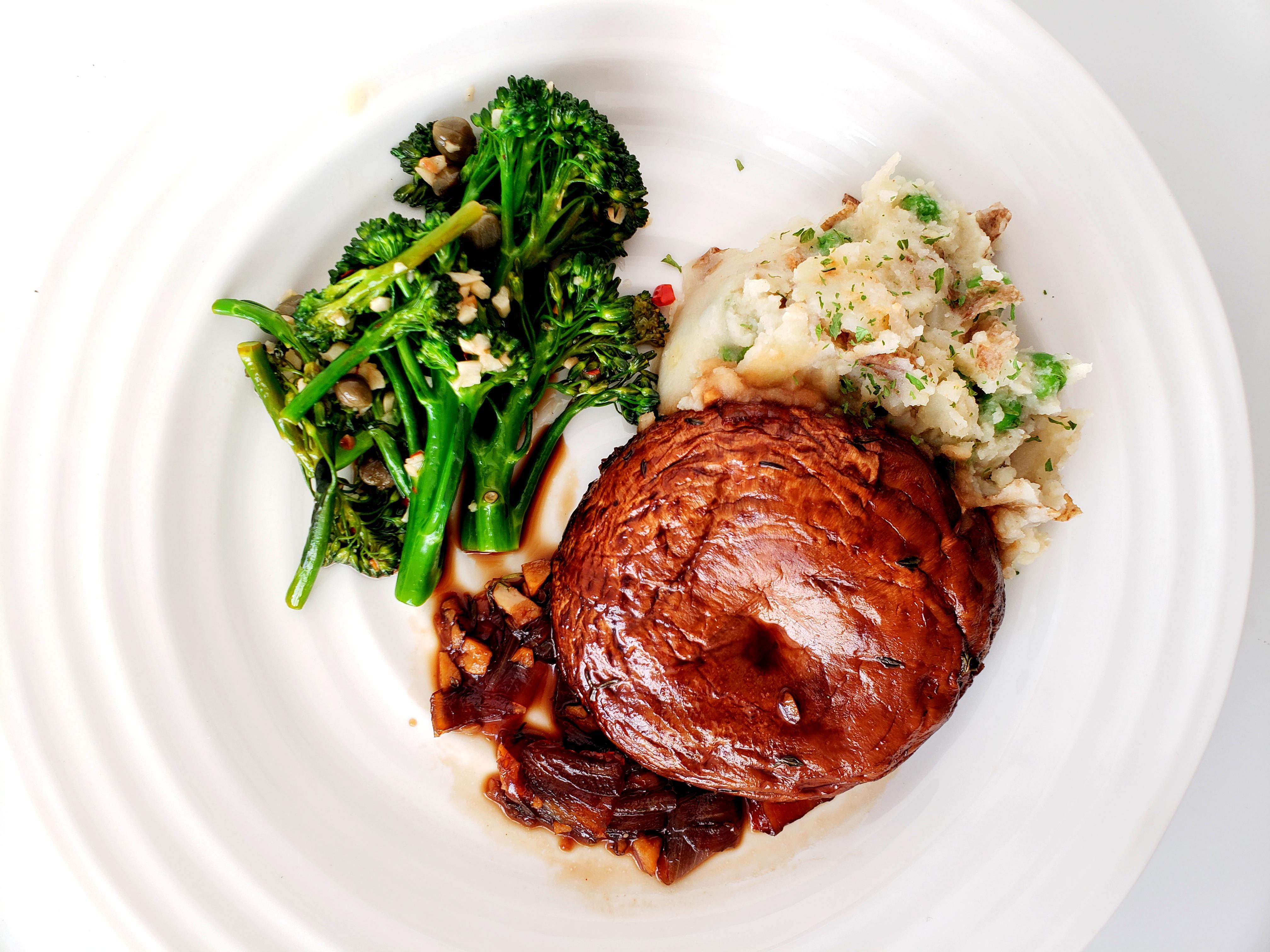 Plate with broccolini, mushroom steak, and mashed potatoes