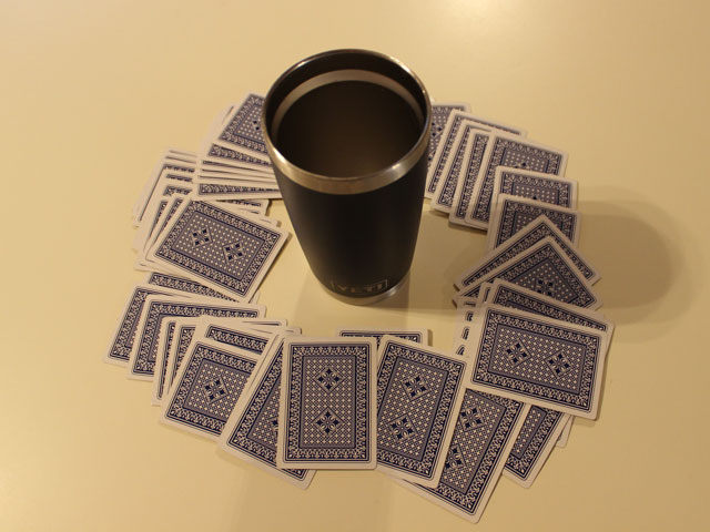 A game of Circle of Death with the cards spread out around the central cup