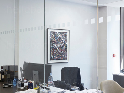 Private office with interior floor to ceiling windows and computer desk next to black office chair Skype background