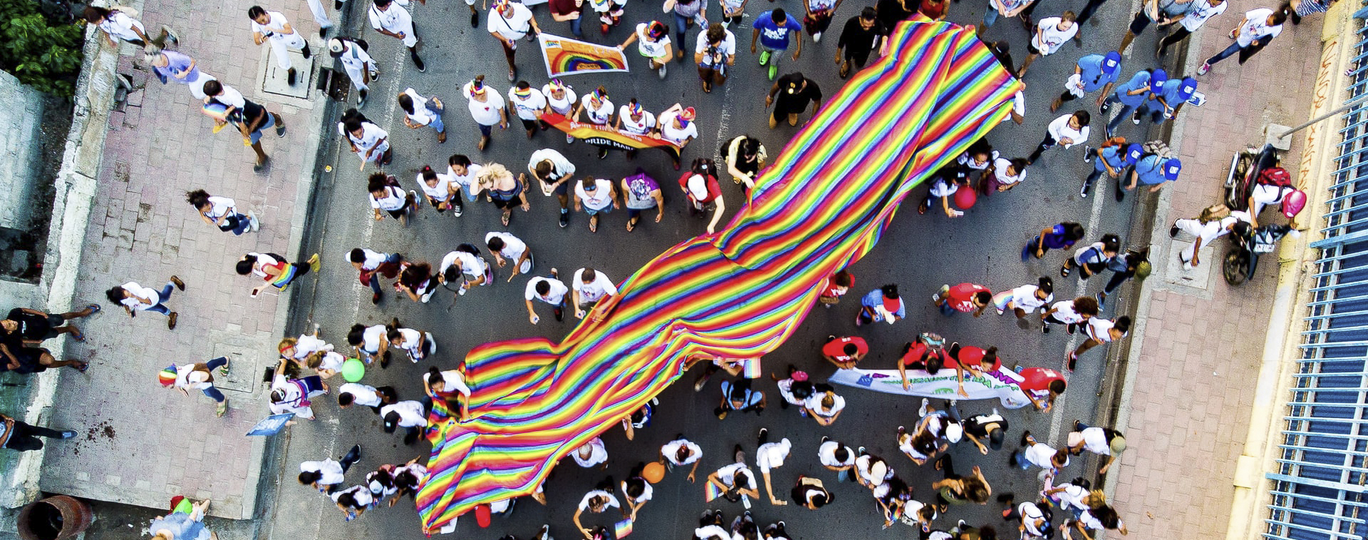 A group of people carrying an LGBTQ pride flag