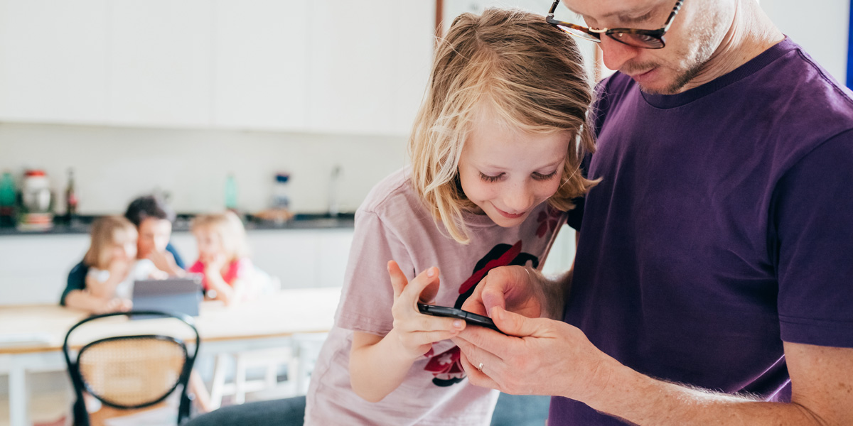 Responsive vs Adaptive Design: What is best for your users? A father and child looking at a phone screen