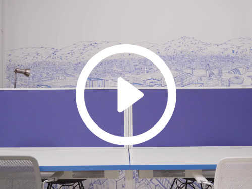 Modern workspace with purple theme featuring wall art behind shared open white and purple desk with two white chairs  Microsoft Teams background