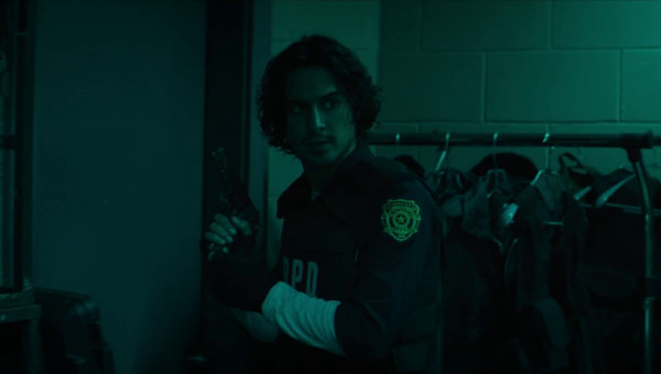 A still from Resident Evil: Welcome to Racoon City showing Leon bathed in teal light, now wearing his customary Resident Evil 2 RPD uniform and bullet proof-vest. He is holding a pistol and looking back over his shoulder at Claire, who is off camera. A still from Resident Evil: Welcome to Racoon City showing Leon bathed in teal light, now wearing his customary Resident Evil 2 RPD uniform and bullet proof-vest. He is holding a pistol and looking back over his shoulder at Claire, who is off camera.
