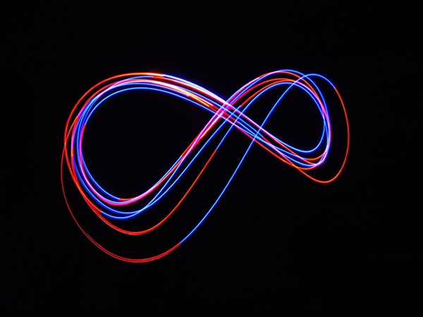 neon infinity sign on black background