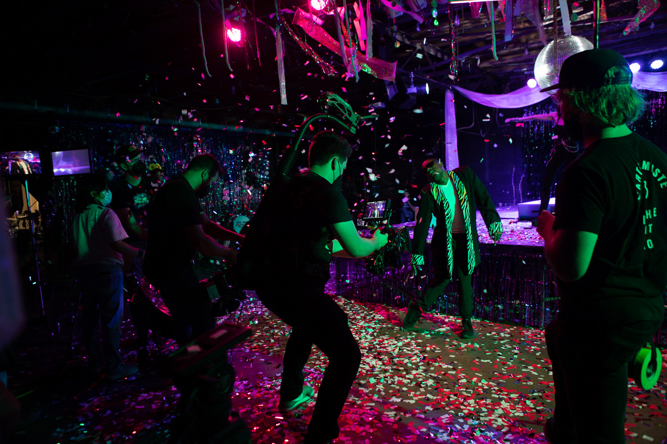 Production team filming a man dancing while confetti is pouring down.