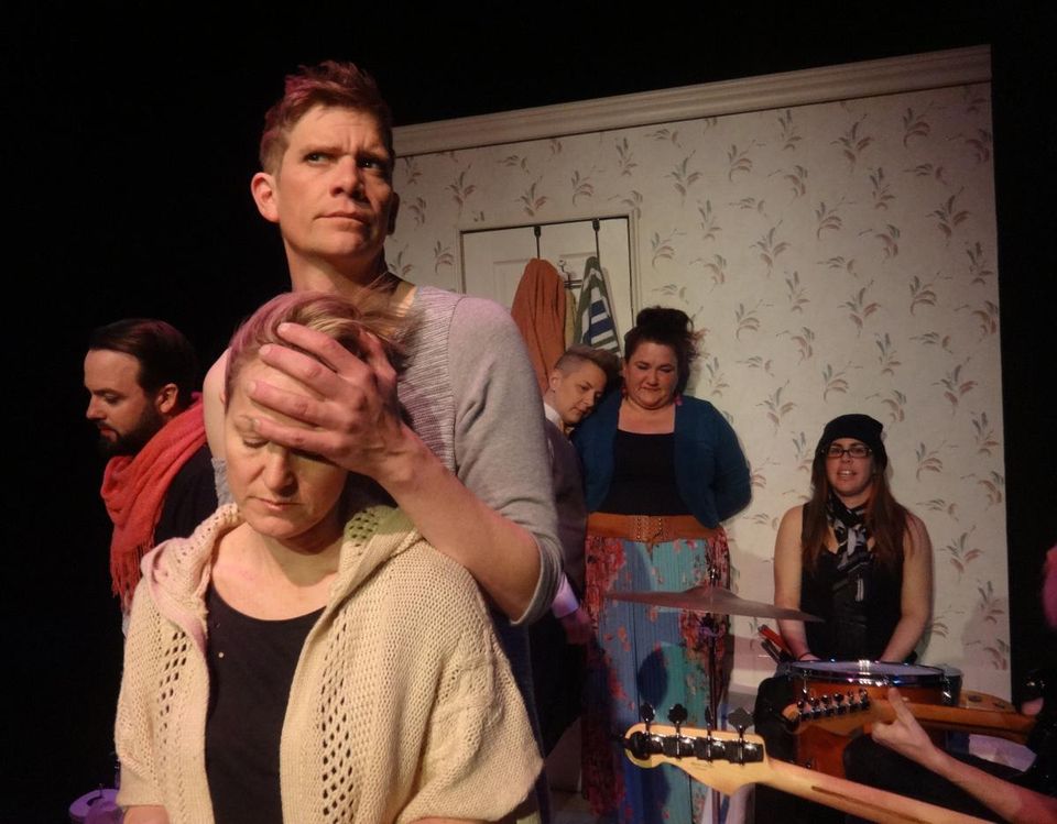 Herman/Sam joined by a hand on a forehead, Jolene rests on Jenny, the Narrator in the background, and the band in the bathtub.