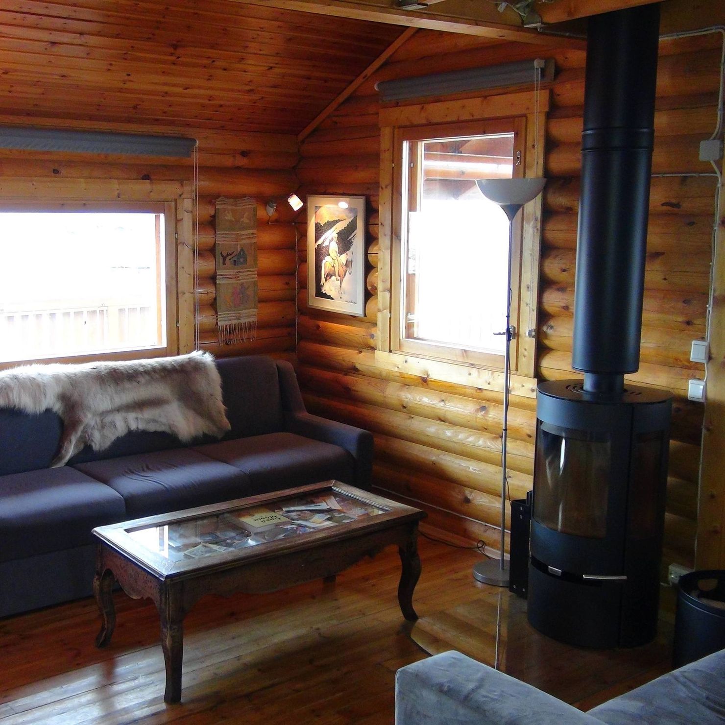In the living room there are couches and a wood stove