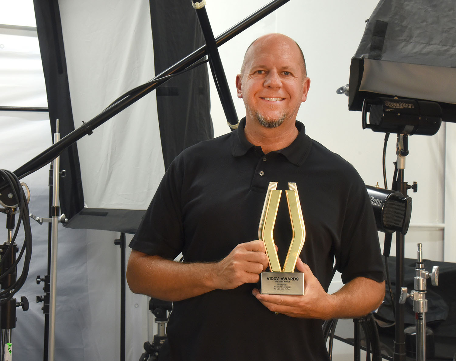Insight Creative’s Creative Director Jay Bauer holding Viddy award