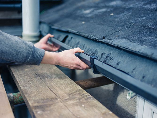 Man hands installing gutter on roof