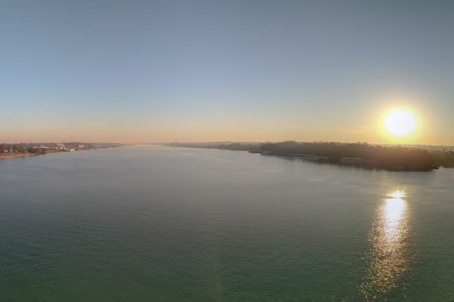 A panorama taken near the center of the Ohio River looking east, just after dawn. The left shore is Indiana, while the right shore is Kentucky.