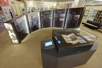 A photo of the main exhibition. The First Folio lies in the showcase in the middle, surrounded by informational walls.