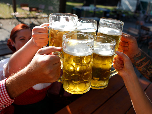 People raising beer steins to clink glasses together