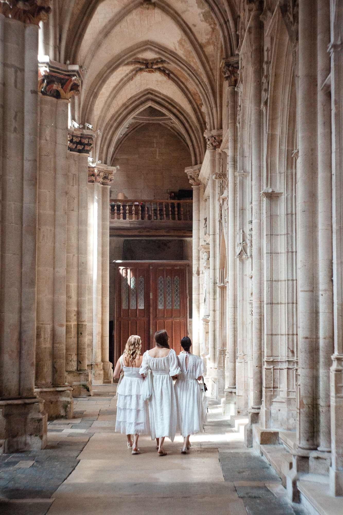 three women in white dresses in an old cathedral