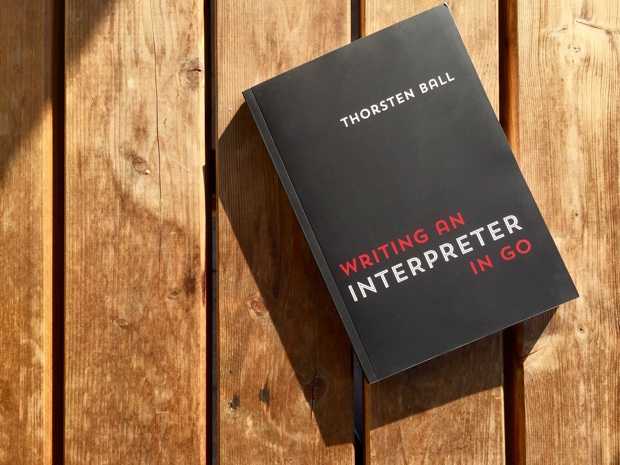 Writing an interpreter in go paperback on wood