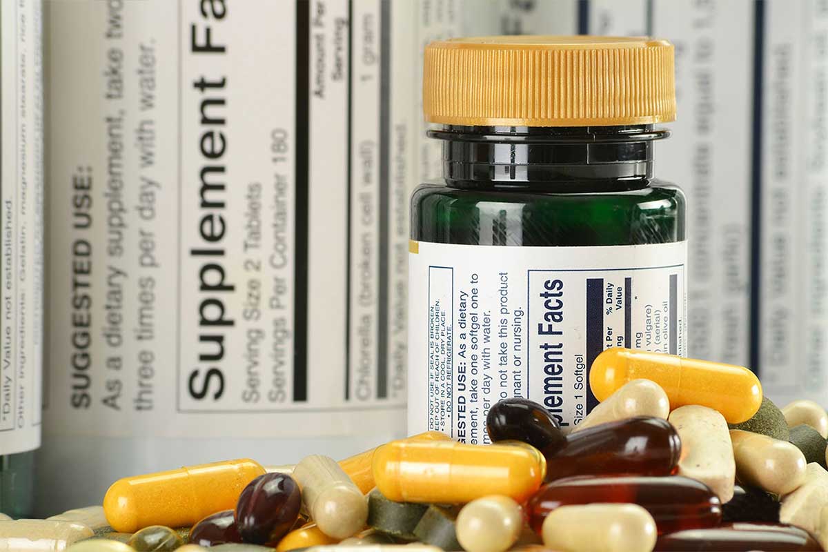 Pill bottle and pills with supplemental nutrition fact sheets.