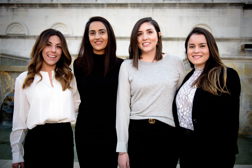 Four women standing up and smiling at the camera