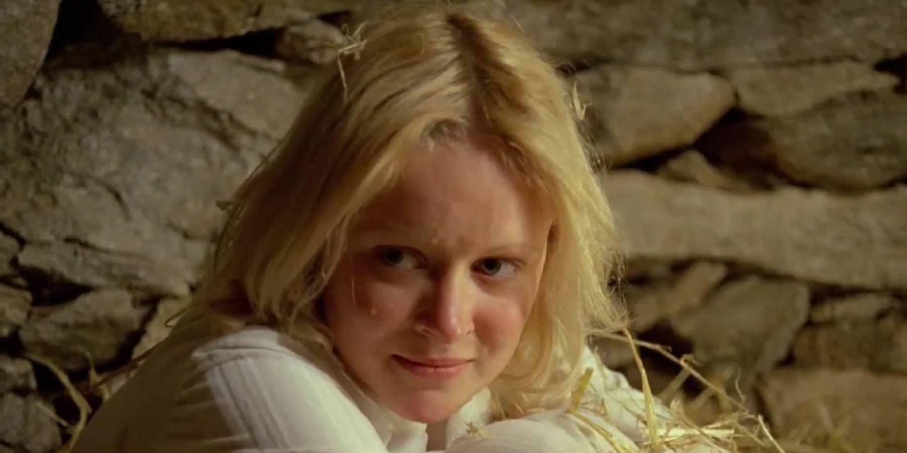 Lead actress Jane Lyle in a still from the movie Island of Death. She is hugging her knees to her shoulders, looking slightly off camera with an expression of schadenfreude.