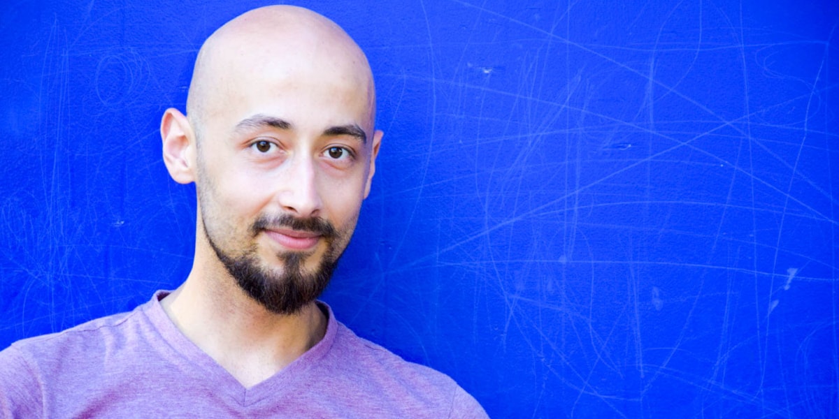 Radi is a data analyst living and working in Berlin Photo of a bald man against a blue background