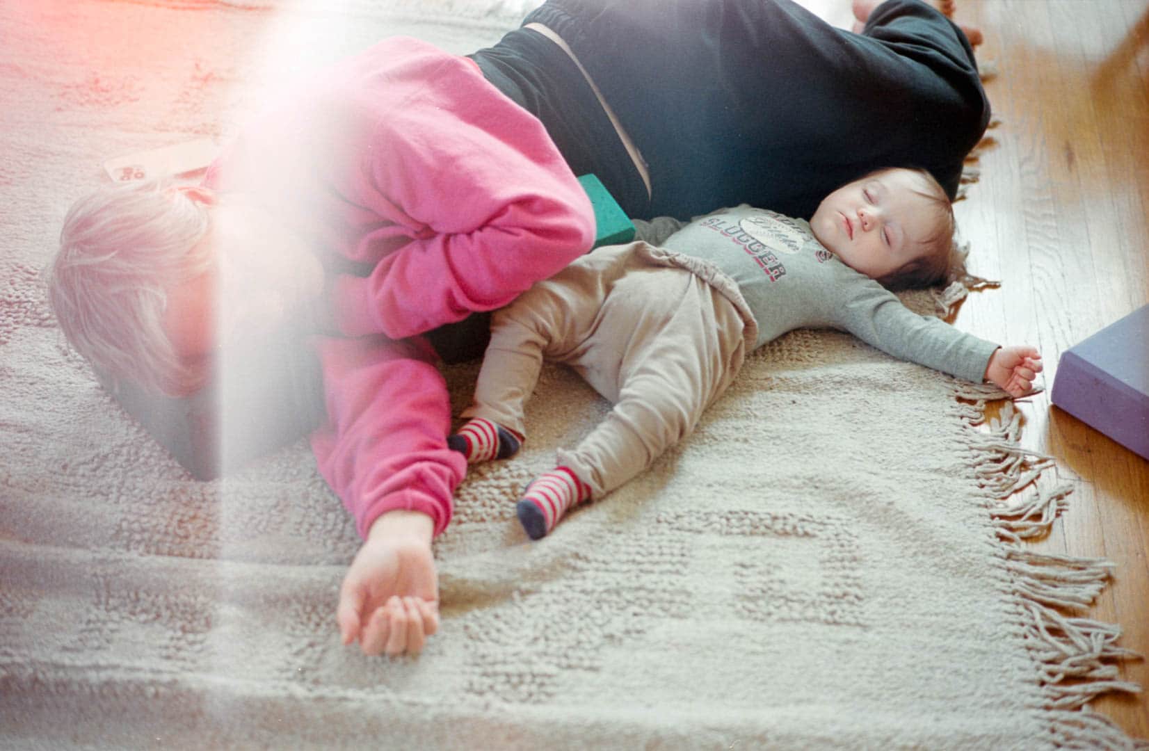 A woman and baby take a nap together on the floor