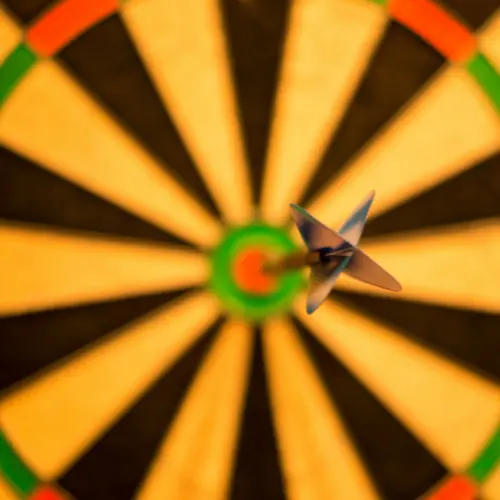 Darts board with a dart on the bullseye, demonstrating a high standard.