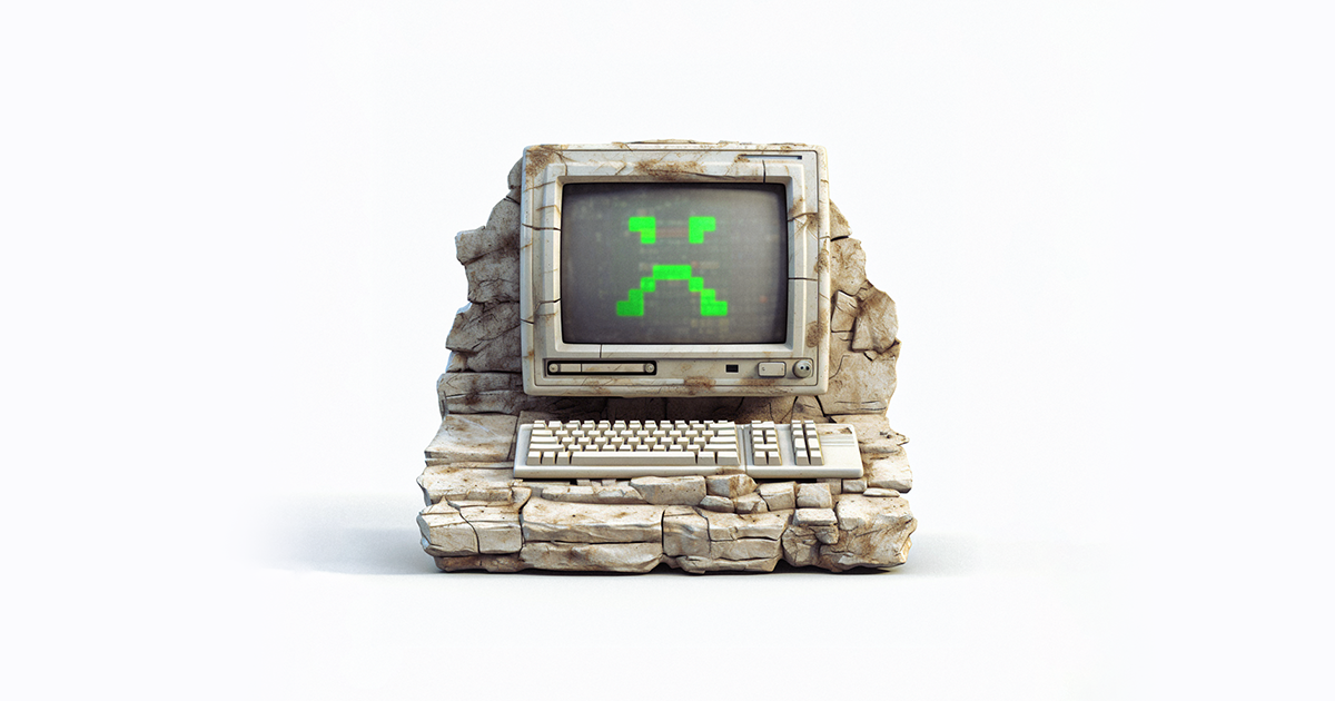 An old computer rendered to look prehistoric, with a digital sad face on the screen.